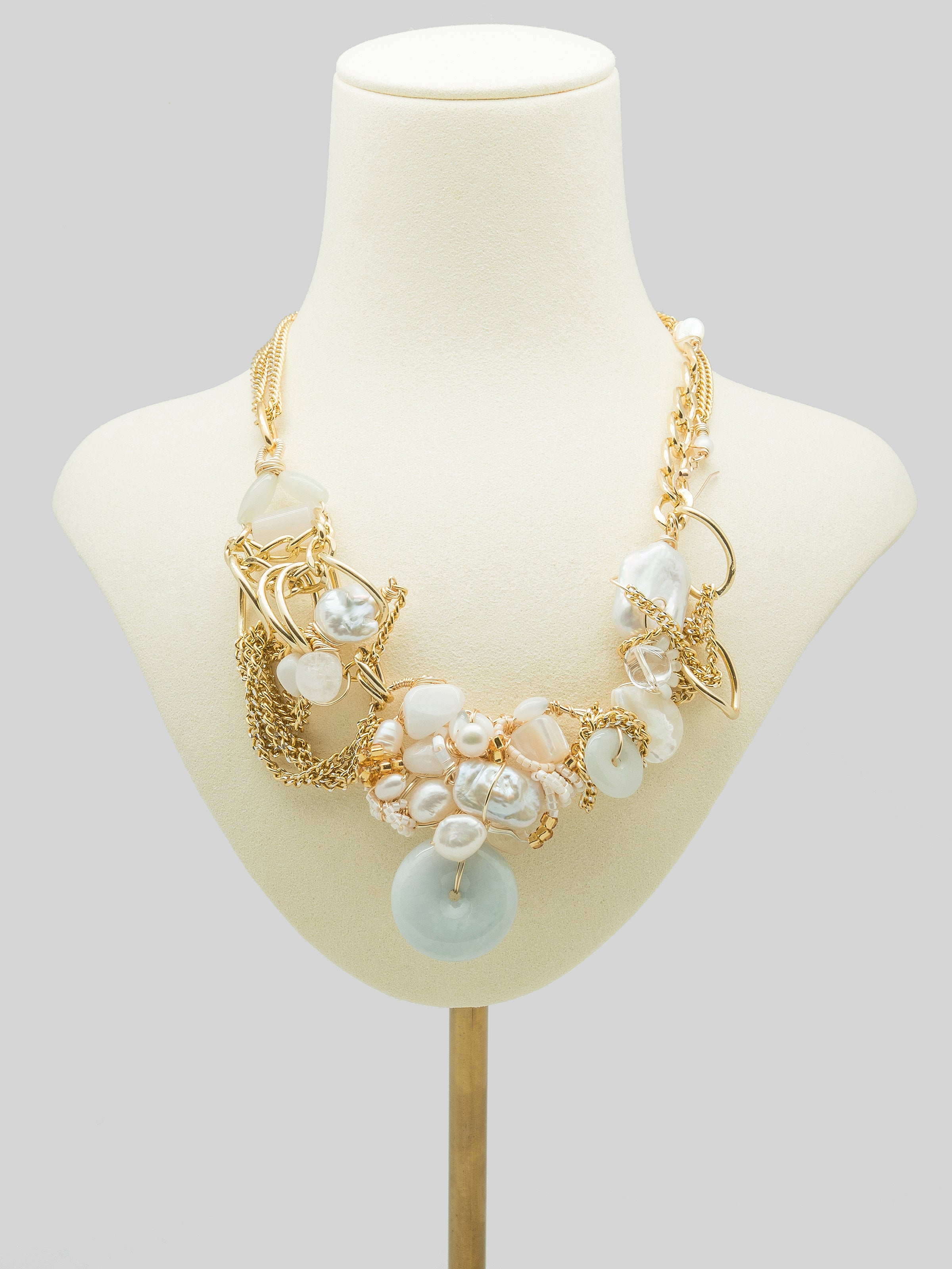 One of a kind necklace with jade doughnut and a galore of pearls, with white agate, quartz, clear quartz, swarovski, and mother of pearl.