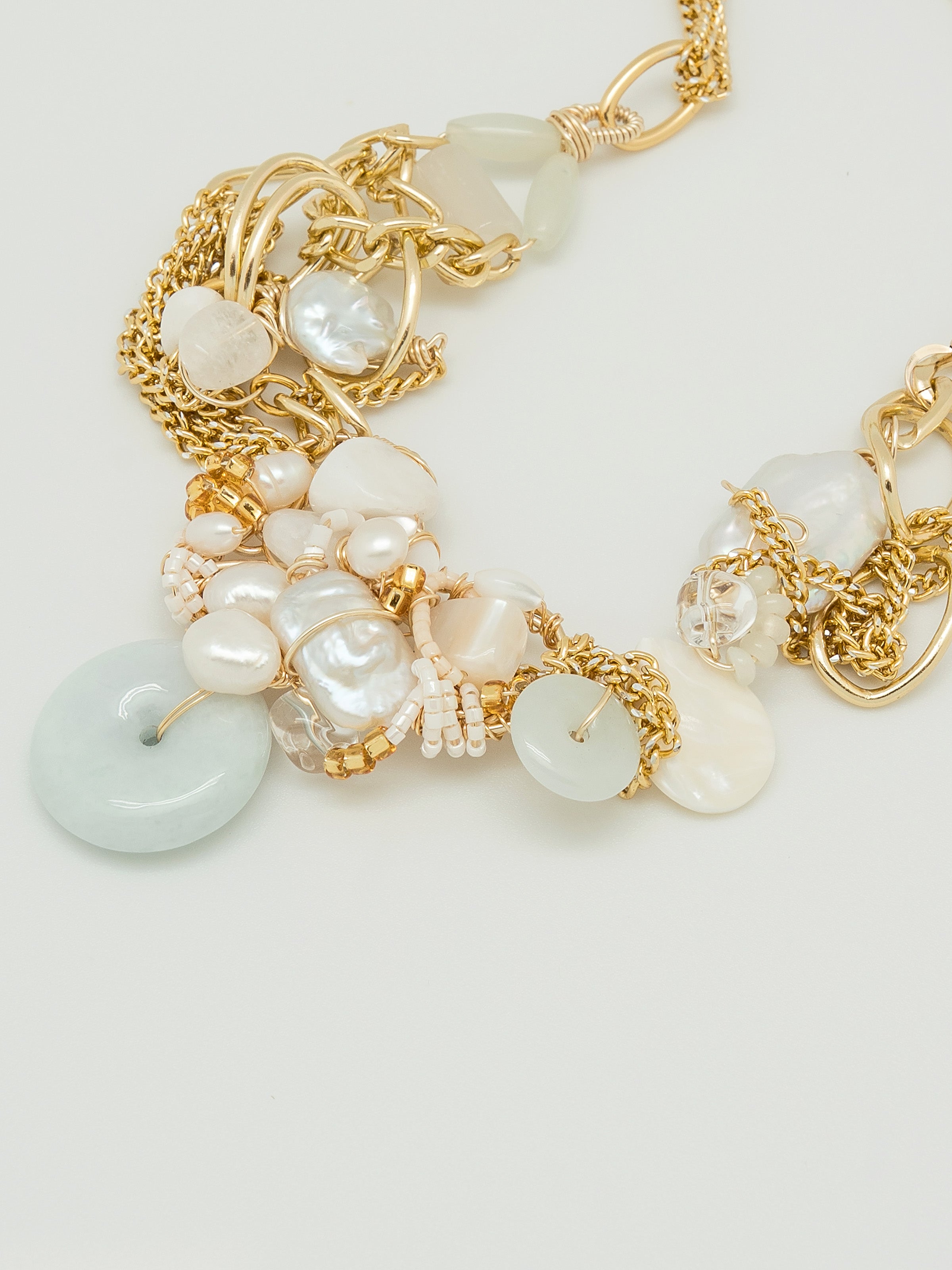 One of a kind necklace with jade doughnut and a galore of pearls, with white agate, quartz, clear quartz, swarovski, and mother of pearl.