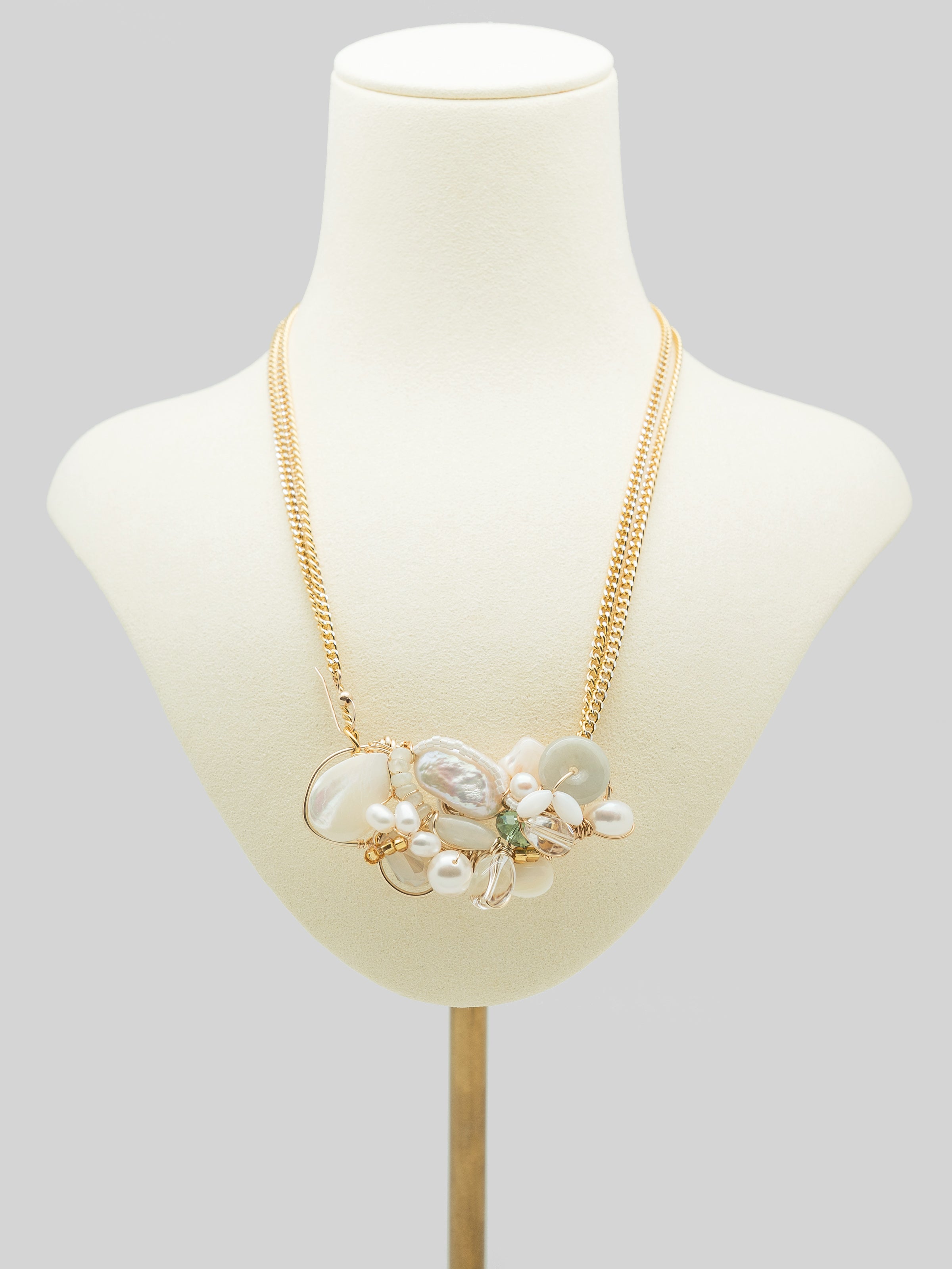 Necklace with light green jade doughnut, freshwater pearls, mother of pearl, swarovski crystals and pearls, toho seed beeds, clear quartz.