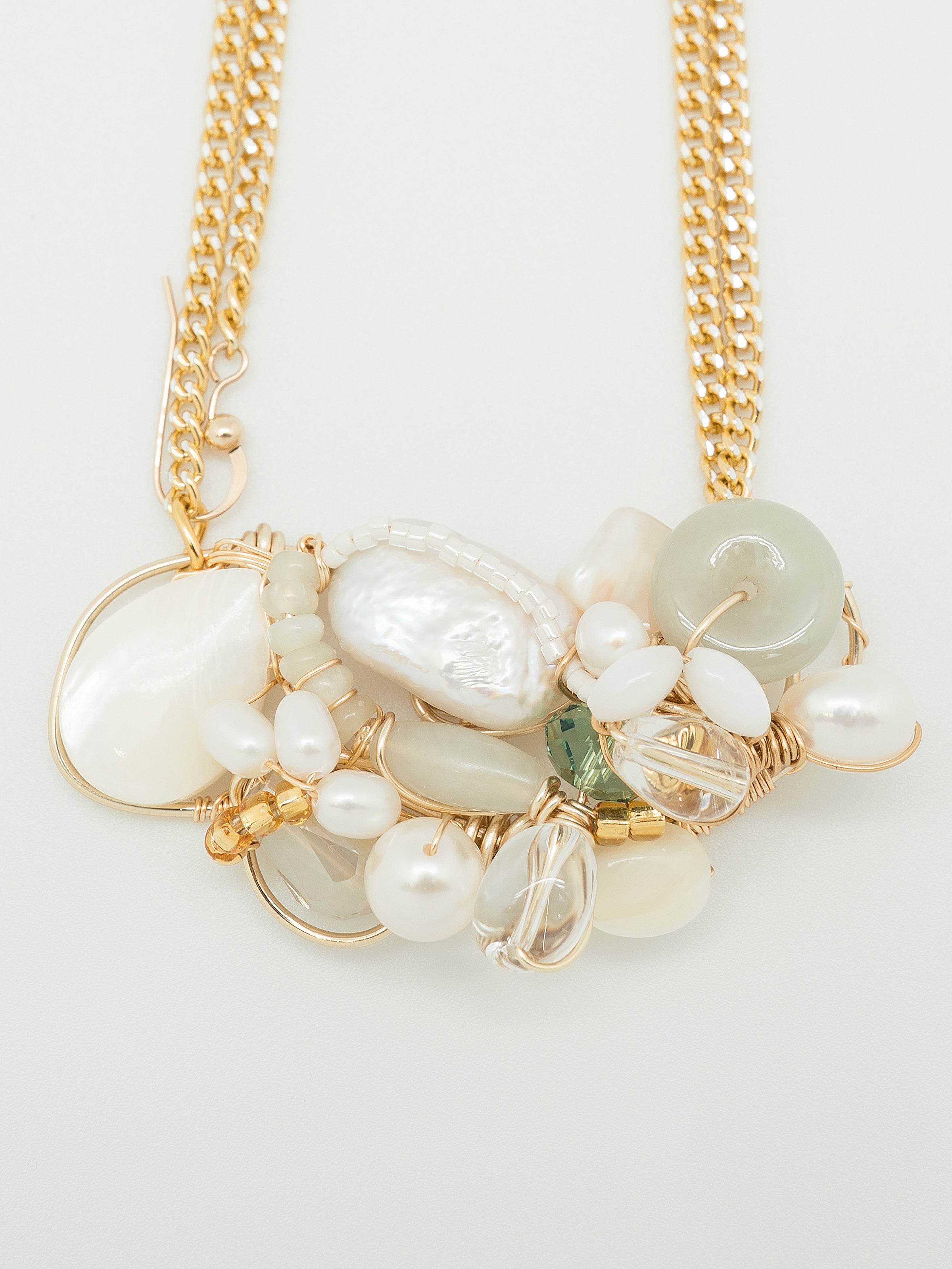Necklace with light green jade doughnut, freshwater pearls, mother of pearl, swarovski crystals and pearls, toho seed beeds, clear quartz.