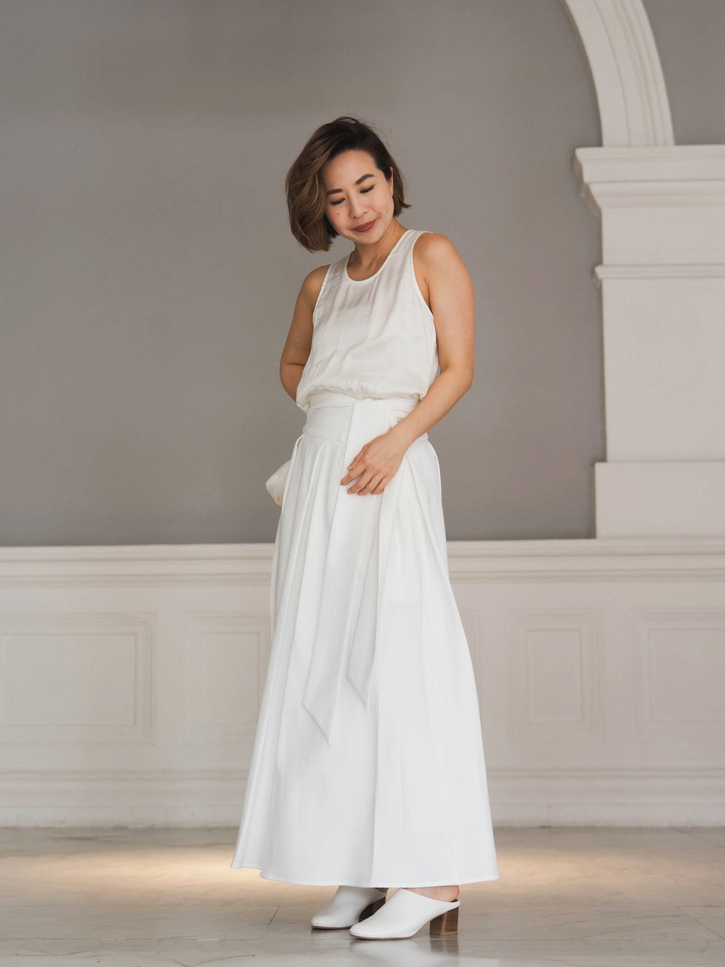 Woman wearing white sleeveless top and white skirt by Singapore women's fashion brand Hadasity.