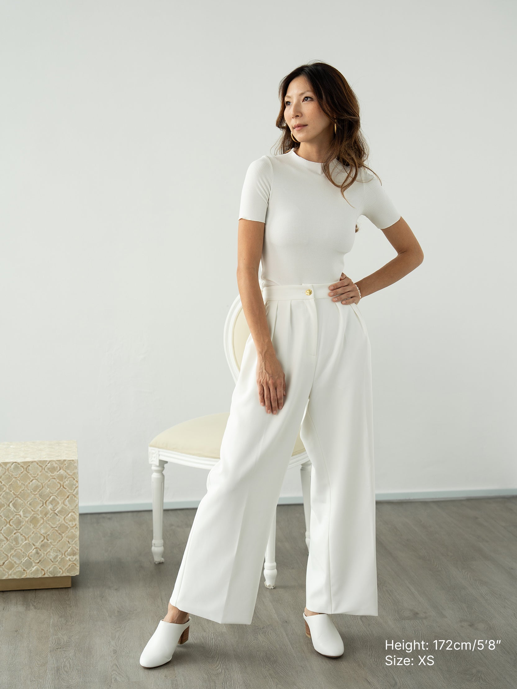 Woman wearing white knitted short sleeved top and white pants by Singapore women's fashion brand Hadasity.