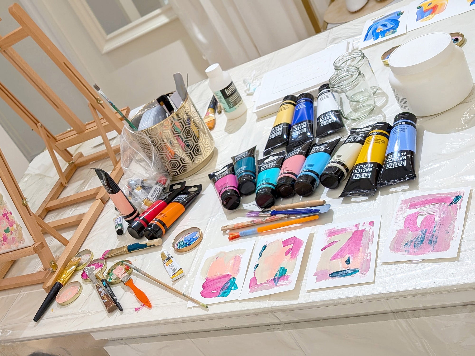 Creative art experience at the Hadasity studio store. Art supplies including paint tubes and brushes on a table with art samples.