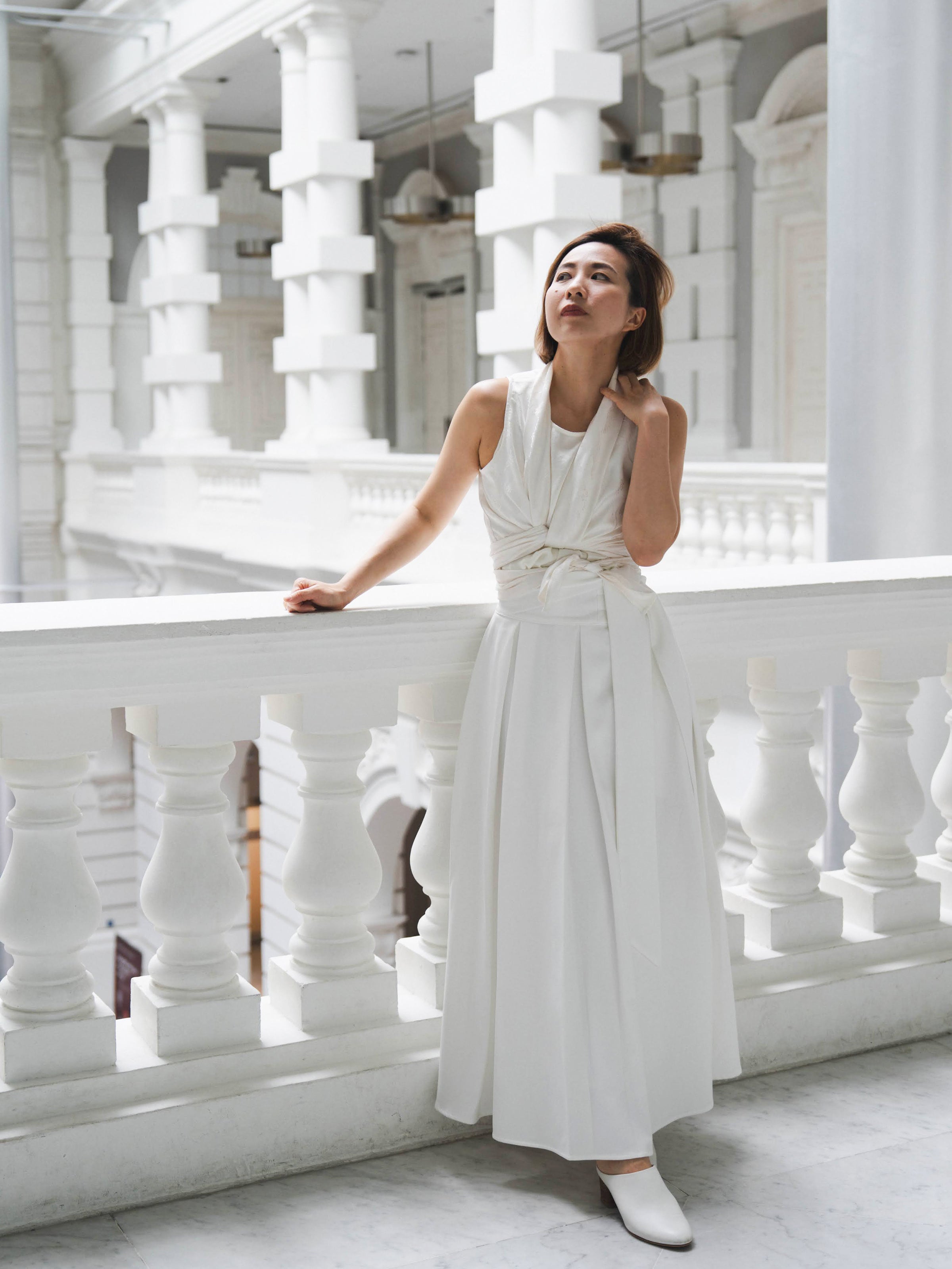 Woman wearing white sleeveless wrapped multi-way top and white skirt by Singapore women's fashion brand Hadasity.