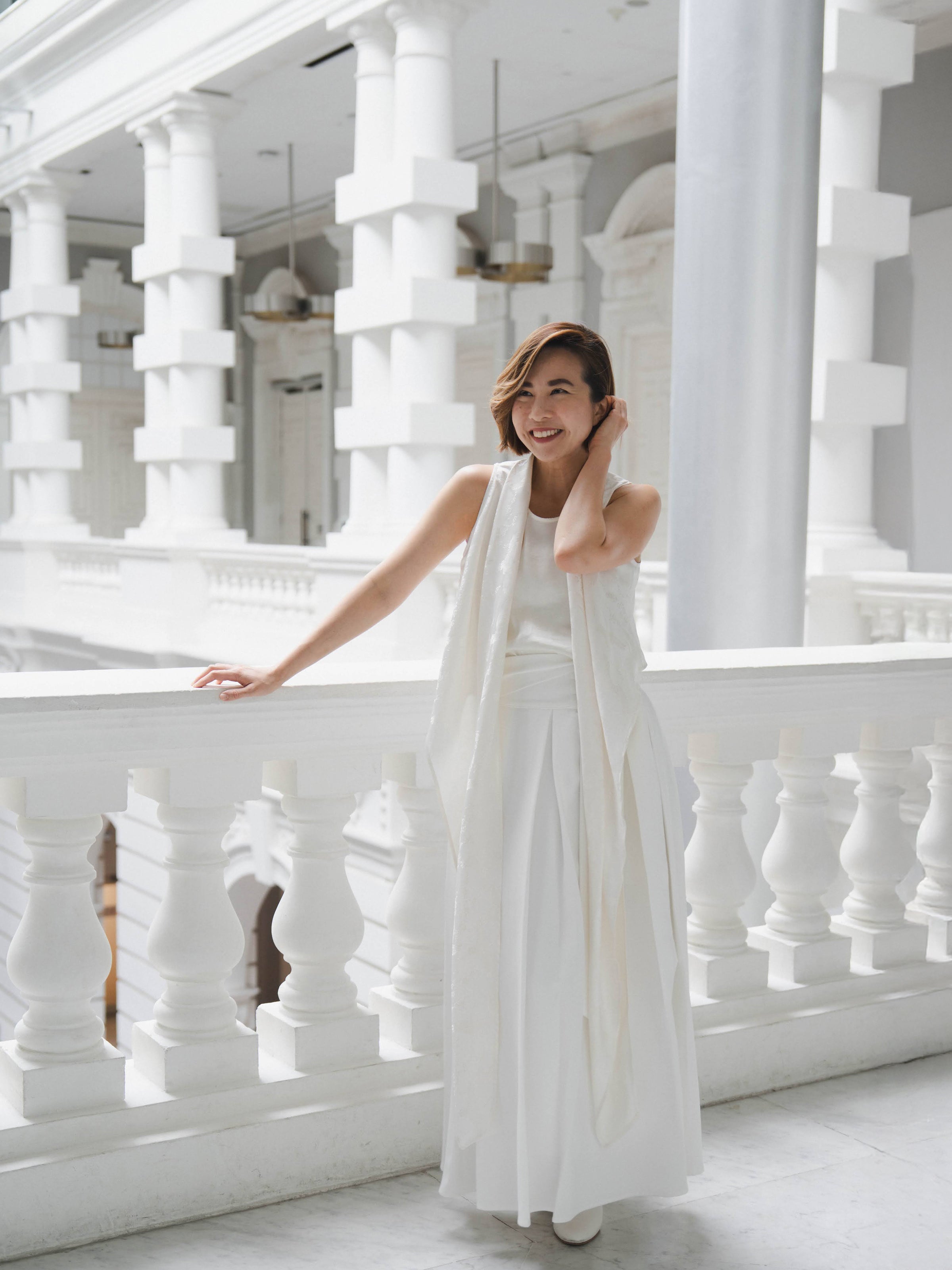 Woman wearing white sleeveless wrapped multi-way top and white skirt by Singapore women's fashion brand Hadasity.