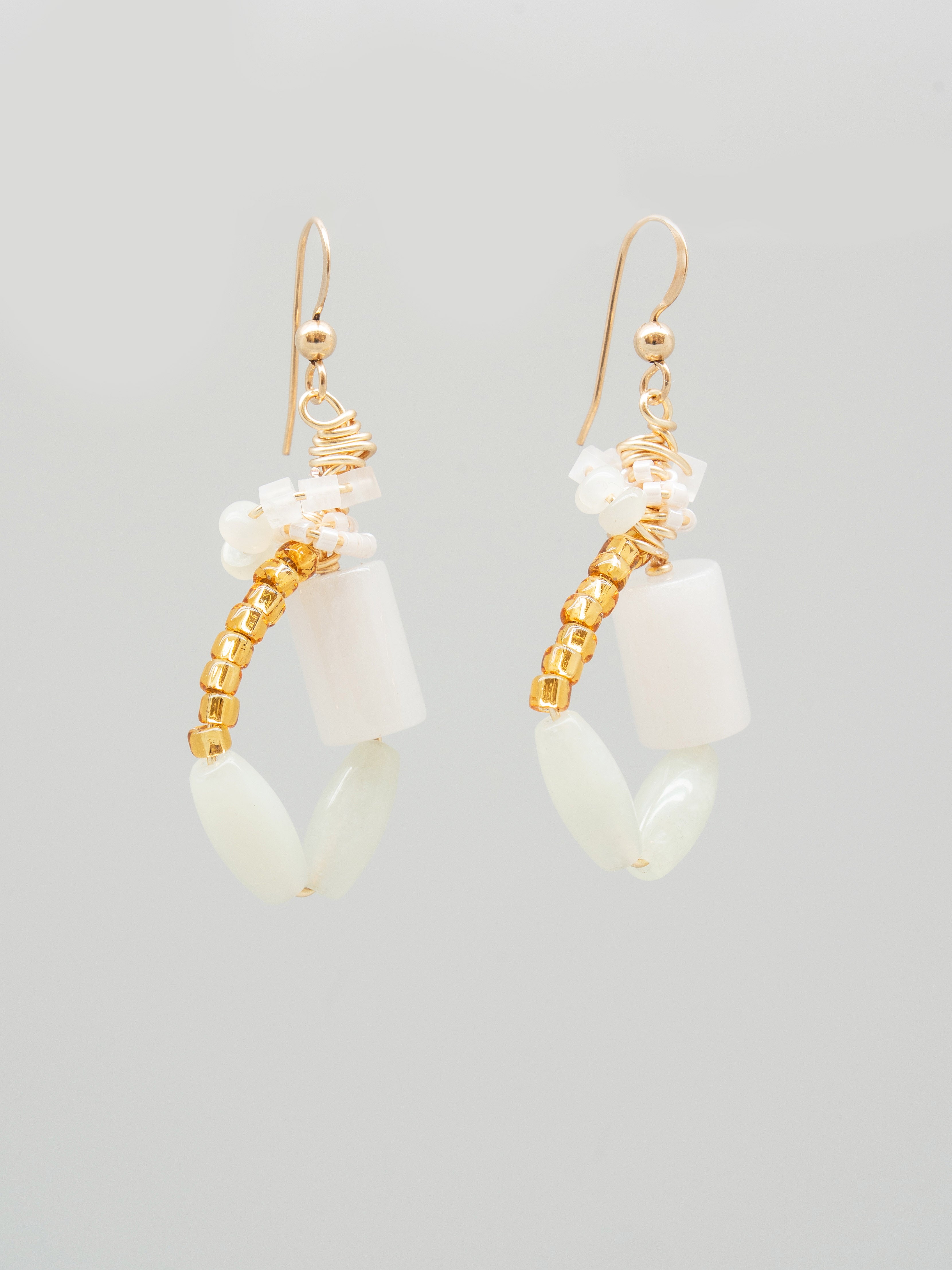 Pair of earrings with white cylindrical beads, pale green beads, and gold white seed beads